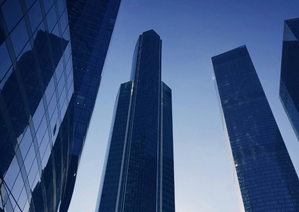 Low angle view of modern skyscrapers in Moscow with a striking morning sun backdrop.